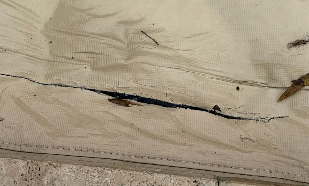 Tear and fabric wear on an automatic pool cover documented during an inspection