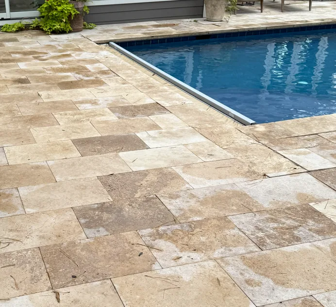 Recessed automatic-cover housing beside stone decking, photographed during an inspection